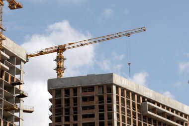İnşaat alanı ve şehir arka planında kule vinçleri