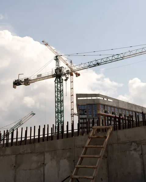 İnşaat alanı ve şehir arka planında kule vinçleri