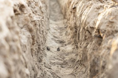 İnşaat alanında su boruları döşemek için siper.