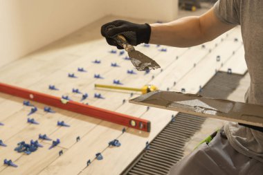 Tamir ve inşaat. Seramik fayansları yere yakın plan çimento döşemek. Bir adam yere ve duvarlara beton döker..