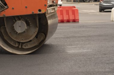 Titreşimli asfalt silindirler, otoyolun yeni asfalt yüzeyini sıkıştırıyor. Yol yetkilileri yeni bir otoyol inşa ediyorlar.