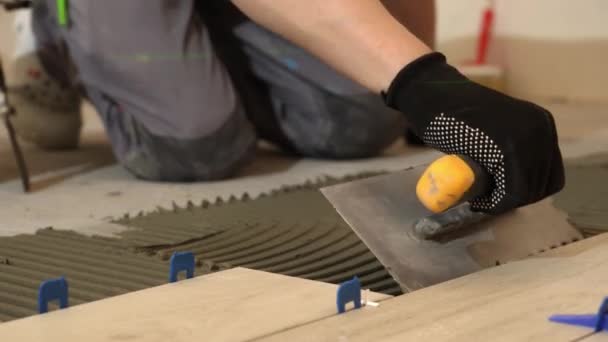 铁匠把地砖铺在地板上 厨房里的瓷砖一个耕作者正在把瓷砖粘在厨房地板上 一个男人在浴室地板上铺瓷砖 — 图库视频影像