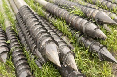 Teras temellerinin canı cehenneme. Jeo vidalar, bir mühendislik yapısının çelik yuvarlak elementleridir. Mimari inşaat işleri için metal aletlerin endüstriyel bakımı.