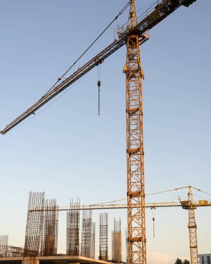 İnşaat alanı ve şehir arka planında kule vinçleri