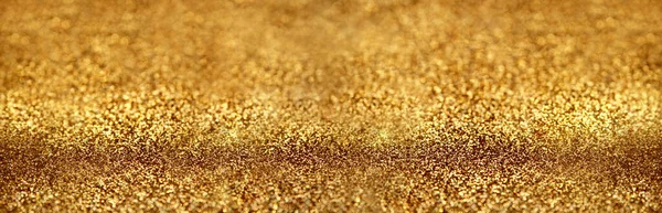 Gold glitter texture sparkling paper background. Abstract twinkled golden glittering background  with bokeh, defocused lights for Christmas holiday banner