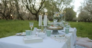 Sakin bir öğleden sonra çiçek açan ağaçların arasında güzel bir açık hava yemek etkinliği yaşayın.