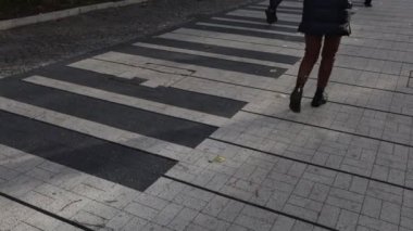 Bir kadın yaya geçidinde güvenle yürüyor, şehir hayatını günlük hayatla harmanlıyor.