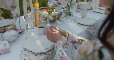 Unutulmaz bir deneyim için zarif sofra takımı ve canlı çiçekler içeren çarpıcı bir açık hava yemek düzeneği.