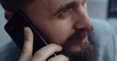 Akıllı telefonunu kullanan bir adamın yakın plan görüntüsü, derin bağlılık ve canlı bir sohbete dahil olma görüntüsü.