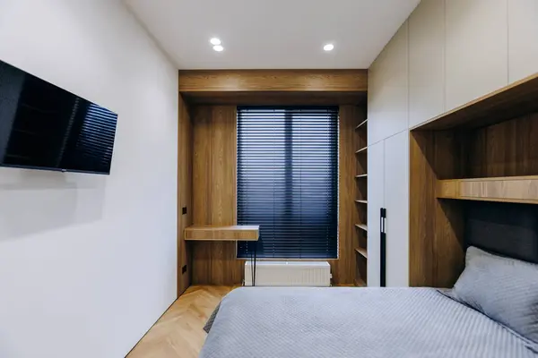 Bu yatak odası şık ve modern, ahşap aksanlı güzel bir minimalist dekor tarzı sergiliyor.