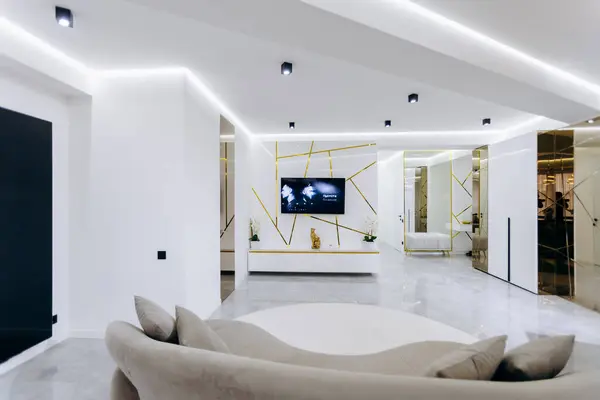 Güzel tasarlanmış yuvarlak bir kanepe ve eğlence için duvara monte edilmiş büyük bir düz ekran televizyon olan rahat bir oturma odası hayal edin.