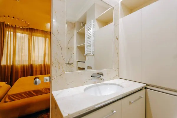 Lavabo özelliği olan iyi tasarlanmış bir banyo. Geniş, zarif bir ayna. Genel estetik çekiciliği arttırıyor.