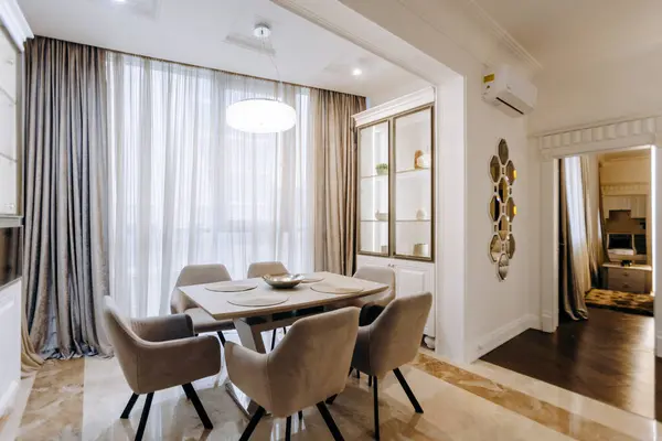 Yemek için tasarlanmış oda, rahat sandalyelerle birlikte güzel bir masa ve doğal ışık sağlayan büyük bir pencere.