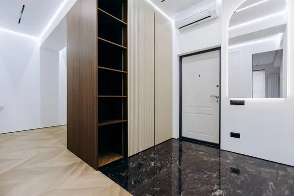 Sıcak ve davetkar bir estetik sergilenirken şık rafların sergilendiği çağdaş bir giriş.