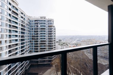 Büyüleyici bir balkon manzarası modern, çağdaş binaları güzel, manzaralı şehir siluetinin yanında sergiliyor.