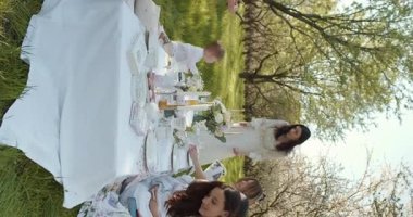 Güzel bir piknik sahnesi, yemyeşil bir ortamda toplanan bir aile, doğanın ve birlikteliğin tadını çıkarıyor..