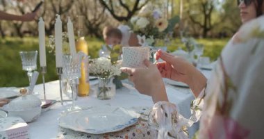 Canlı çiçekler ve parlayan mumlarla süslenmiş canlı bir toplantı için nefis bir açık hava yemek düzenlemesi.
