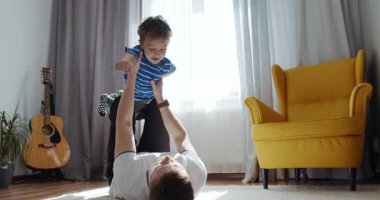 Yürek ısıtan bir video, sıcak bir oturma odasında bebeğini şefkatle tutan bir babayı gösteriyor. Onların neşeli etkileşimleri onların sevgi bağlarını vurgular.