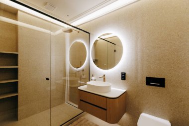 Lavabo, tuvalet, duş ve günlük ihtiyaçlarınız için bir ayna gibi temel unsurları barındıran iyi tasarlanmış bir banyo.