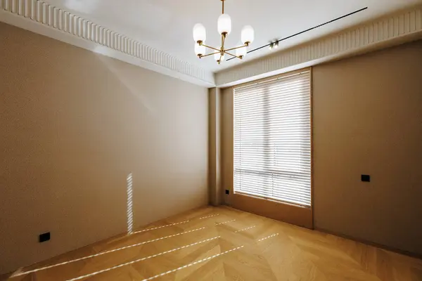 Boş bir odada, güzel bir avize zarifçe tavandan sarkıyor, yumuşak ışığıyla mekanı aydınlatıyor.