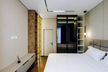 Burası rahat bir yatak odası. Geniş, geniş bir yatak odası. Kıyafetlerinizi düzenli tutacak bir gardırop da var.