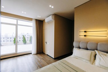 Geniş, geniş, rahat bir yatağı olan rahat bir yatak odası. Büyük bir pencereyle tamamlanmış. Bol miktarda doğal ışık getiriyor.