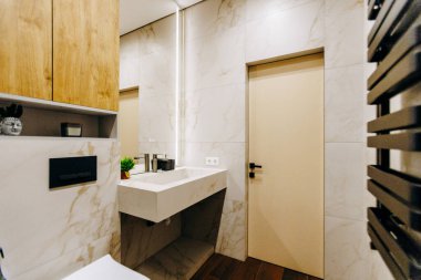 Tuvalet, lavabo ve pratik kullanım için ayna gibi temel konforları barındıran bir banyo.