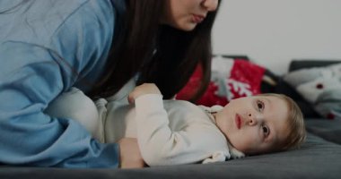 Yürek ısıtan bir video, bir kadının rahat bir yatakta bebekle bağ kurduğunu, neşeli etkileşimleri, hassas anları ve bebek bezi değişimlerini kaydettiğini gösteriyor.