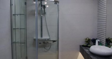 Bu video modern bir banyoya işaret ediyor. Yürüyen bir duş, parlak cam kapılar, çağdaş bir lavabo ve şık bir ayna, temizliği ve işlevselliği vurguluyor.
