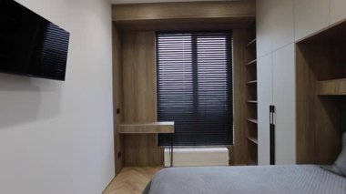 Bu videoda rahat bir yatak odası, eğlence için bir televizyon ve doğal ışık sergileniyor. Huzurlu bir atmosfer yaratıyor.