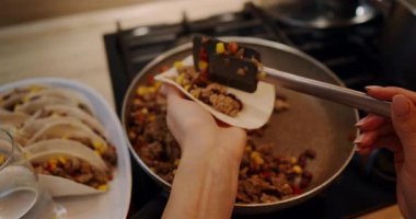 Bu video baştan sona lezzetli tacoların nasıl hazırlandığını gösteriyor, canlı bir sunum için tava ve spatula kullanan usta bir aşçıyla.