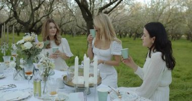 Güzel çiçeklerle çevrili şık bir brunch 'ın keyfini çıkaran büyüleyici bir açık hava sahnesi.