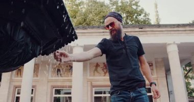 Tarz sahibi bir adam duraksamak ve açık hava ortamındaki fıskiyenin çarpıcı güzelliğinden zevk almak için bir dakikasını ayırır.