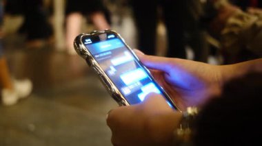 Bir insan elinde cep telefonu tutuyor, o temel taşınabilir iletişim cihazı, parmakları nazikçe kavrıyor.
