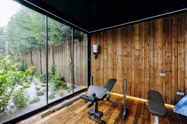 Bu yapı boyunca ahşap duvarları olan bir spor salonu, idmanlar için sağlam bir bank, ve doğal ışığın içeri girmesine izin veren büyük bir pencere.