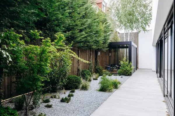 Güzel ağaçlarla çevrili, dingin bir ortamda yemyeşil çalılarla çevrili güzel bir eve götüren büyüleyici bir yürüyüş yolu.