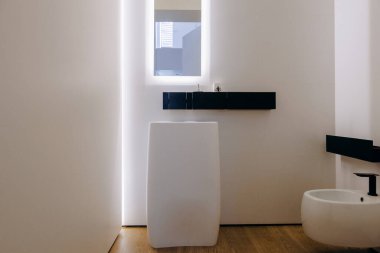 Lavabo, tuvalet ve estetik cazibe ve işlevselliği arttırmak için şık bir ayna içeren iyi tasarlanmış bir banyo.