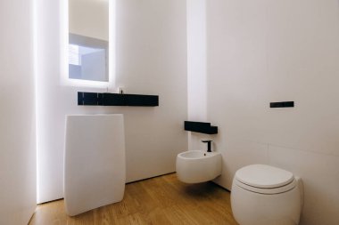 Burası lavabo, tuvalet, bidet ve kullanışlı ve işlevsellik için büyük bir ayna gibi temel konforları barındıran kuytu bir banyo.