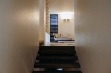 Rahatlamak ve eğlenmek için rahat bir kanepe bulabileceğiniz rahat bir oturma odasına çıkan bir merdiven var.