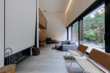 Bu oturma odasında rahat bir kanepe, birkaç sandalye ve ısıtıcı bir şömine var. Rahatlamak için rahat bir ortam yaratıyor.