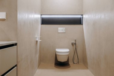 Geliştirilmiş rahatlık ve hijyen için yanında modern bir tuvaletin olduğu kuytu bir banyo.