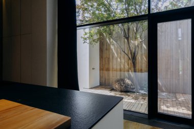 Bu, sağlam ahşap bir masa ile tamamlanmış geniş doğal ışığın içeri akmasına olanak sağlayan geniş bir pencereye sahip bir mutfak.