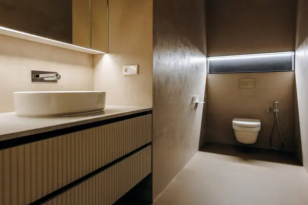 Lavabo, tuvalet ve ek işlevsellik ve rahatlık için ayna gibi temel özellikleri içeren iyi tasarlanmış bir banyo.