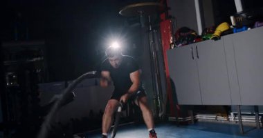 Loş bir boks ringinde, kararlı bir adam yeteneklerini yoğun bir maçta sergiliyor, gölgeler rakibine odaklandıkça dramayı arttırıyor.