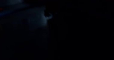 Loş bir boks ringinde, kararlı bir adam yeteneklerini yoğun bir maçta sergiliyor, gölgeler rakibine odaklandıkça dramayı arttırıyor.