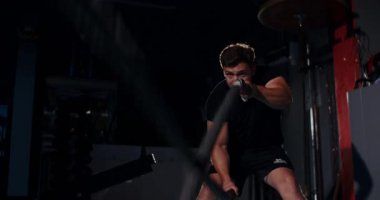 Loş bir boks ringinde, kararlı bir adam yeteneklerini yoğun bir maçta sergiliyor, gölgeler rakibine odaklandıkça dramayı arttırıyor.