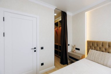 Bu şık yatak odasında rahat bir dekor ve ideal uzay kullanımı için zekice gizlenmiş bir gardırop var.