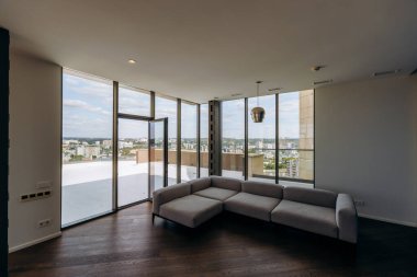 Modern ve çağdaş bir yaşam alanı. Geniş geniş pencereler ve konforlu bir bölmeli kanepe.