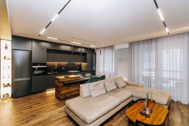 Konforlu bir kanepe, modern bir mutfak ve zarif bir dekor içeren lüks bir yaşam alanı.