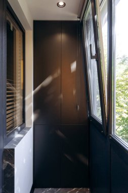 Bol miktarda doğal ışıkla dolu minimalist bir tasarımı sergileyen şık bir iç mekan balkonu.